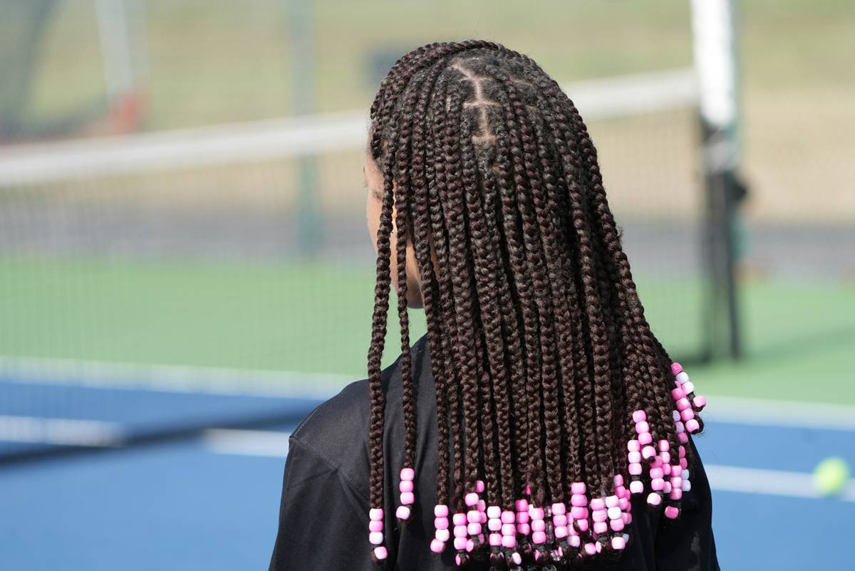 Side-by-side comparison showing knotless braid technique with gradual feed-in vs. traditional cornrow with thick base knot causing scalp tension