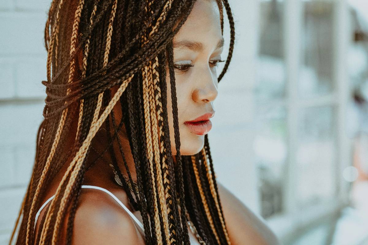 Side-by-side visual showing standard box braids vs. true micro braids (1-2mm thick), with ruler for scale